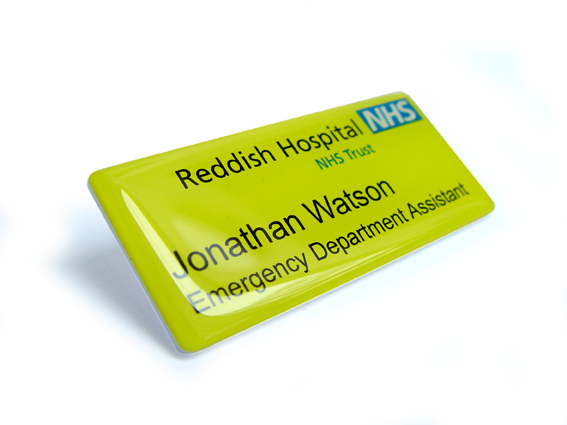 Close-up photograph of a domed personalised name badge